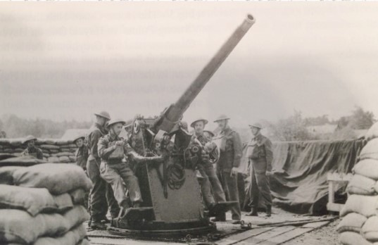 WW2 artillery men around large gun