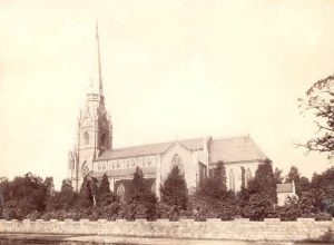 black and white picture of large church with steeple